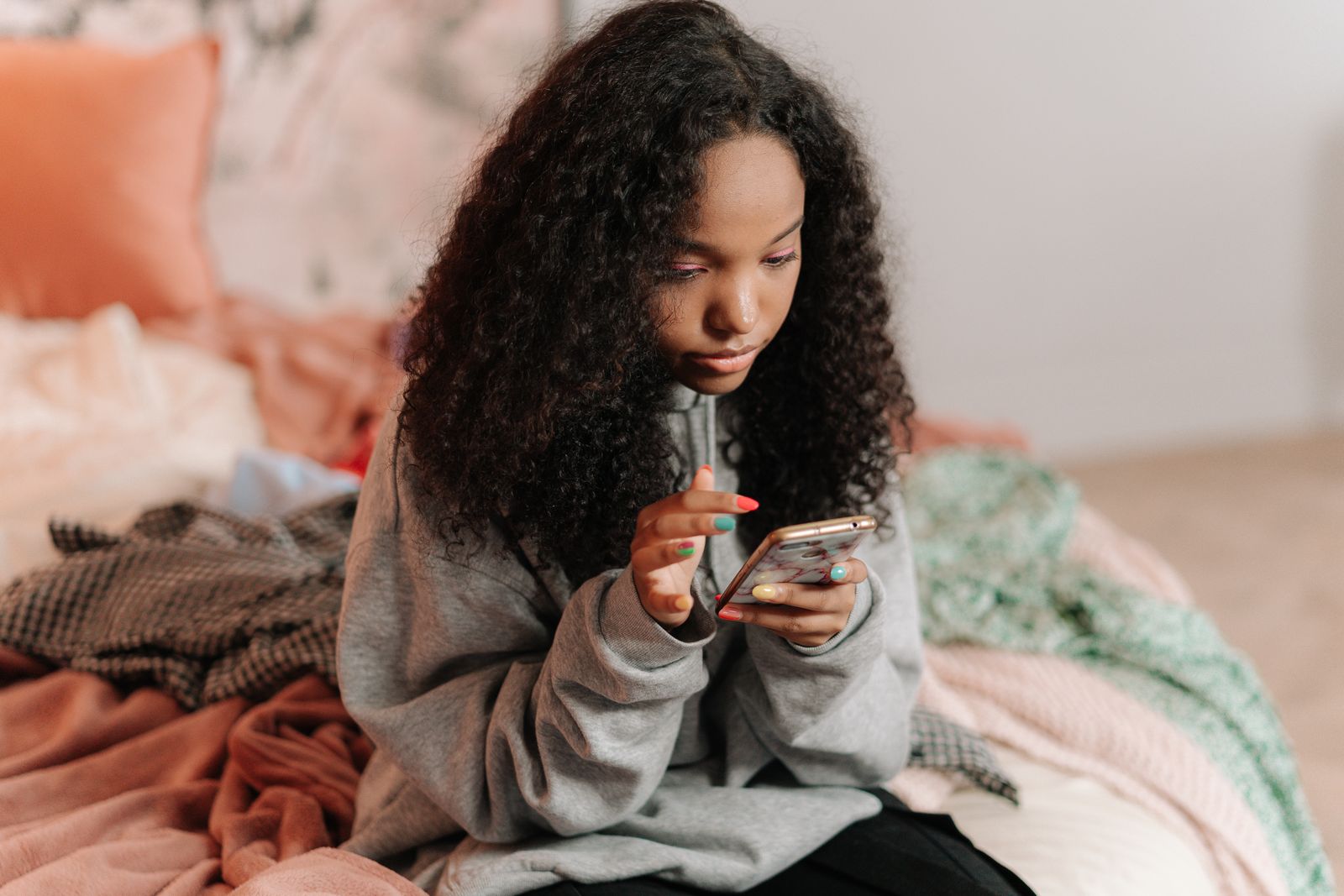 Adolescente usando un teléfono en su habitación